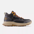 New Balance Foam X Hierro Mid GTX hiking boots in dark gray with orange accents, Gore-Tex upper, and beige Vibram outsole, side view.