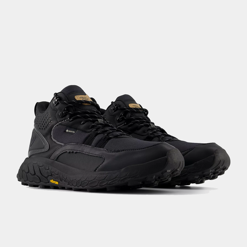 New Balance Foam X Hierro Mid GTX hiking boots in black with Gore-Tex waterproof upper and Vibram outsole, front-angle view.