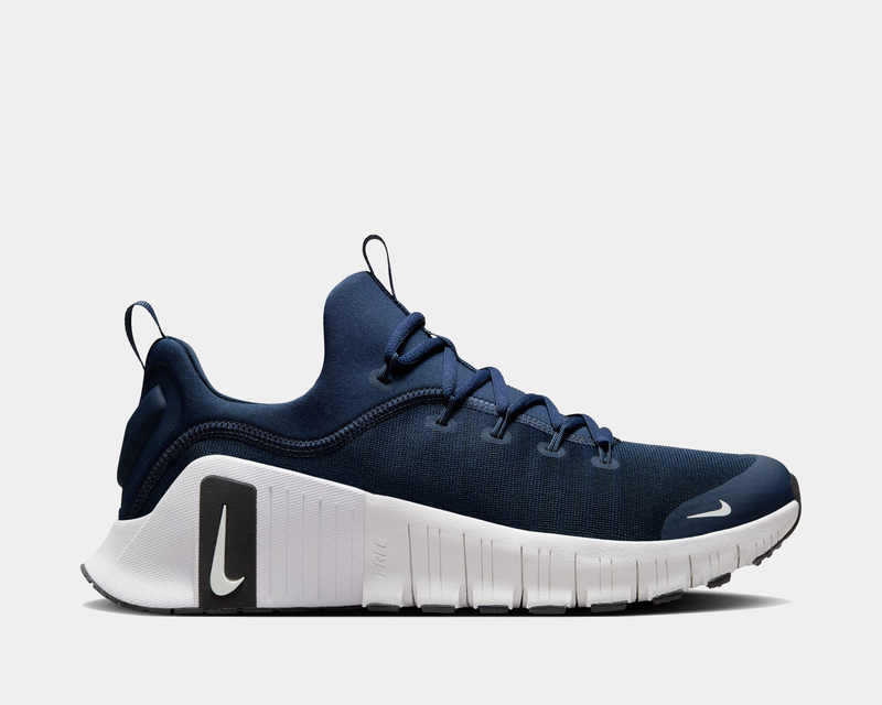 Nike Free Metcon 6 TB training shoes in navy blue with mesh upper, white midsole, and Nike logo accents, side view.