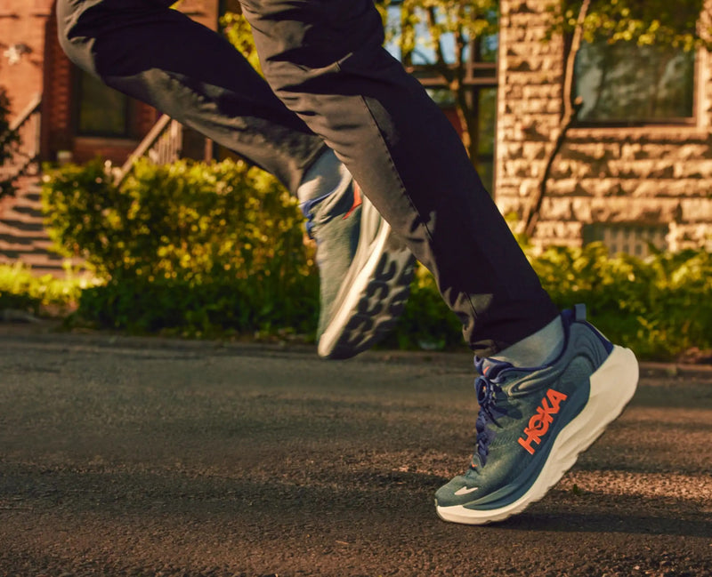 HOKA Gaviota 6 running shoes in teal with orange logo, robust cushioning, and white sole, worn by a runner outdoors