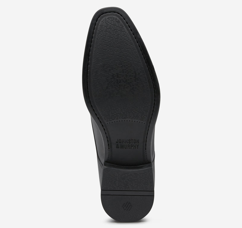 Johnston & Murphy Gibbons Cap Toe outsole in black rubber with textured grip and embossed branding, sole view.