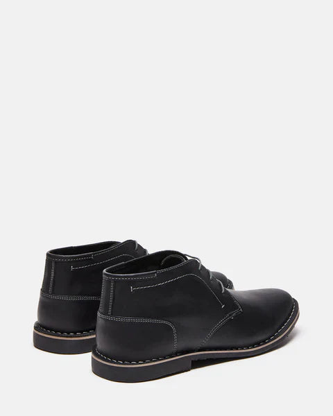 Steve Madden Harken boots in black leather with stitched detailing and sturdy soles, back angle view.