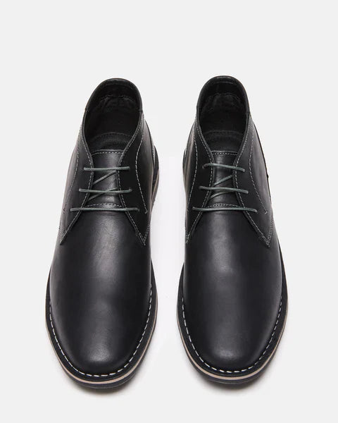Steve Madden Harken dress boots in black leather with stitched detailing and round toes, top view showing lace-up design.