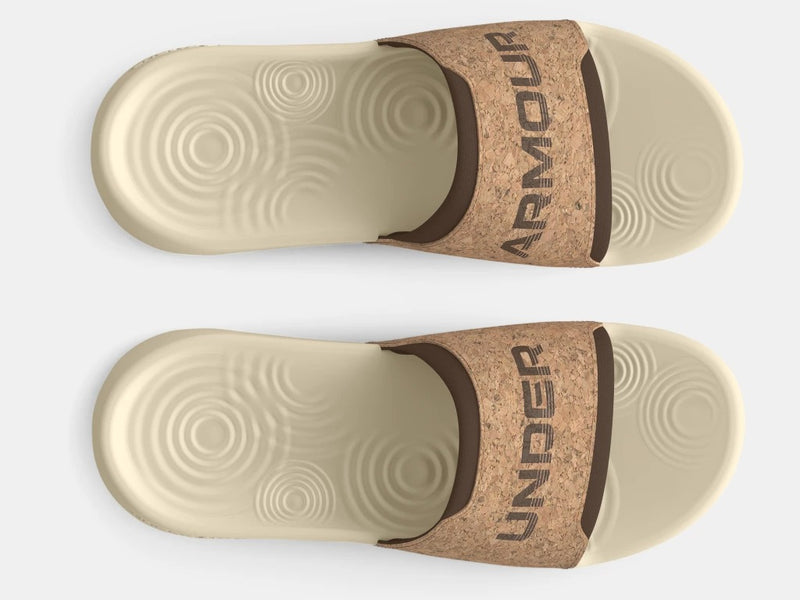 Under Armour Ignite Select Cork Slides in beige with cork-textured strap and cushioned footbed, top view.