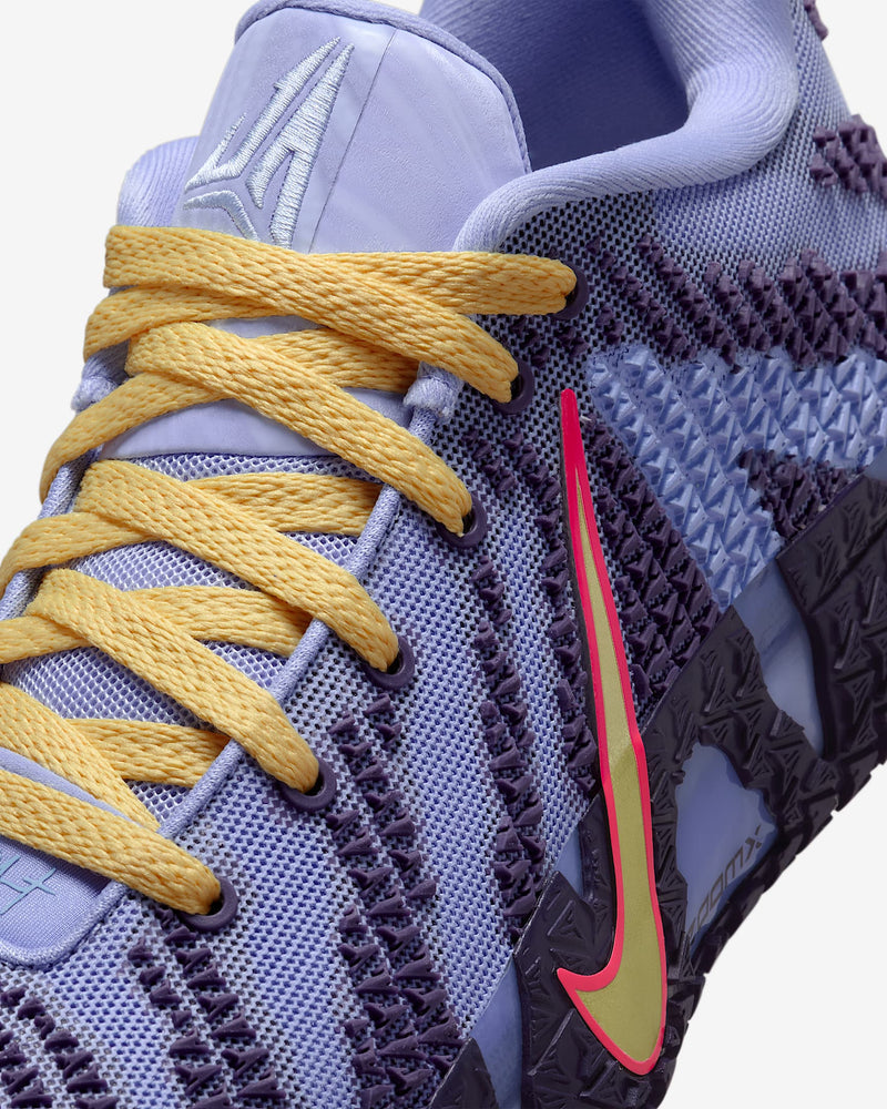 Nike Ja 3 "Channel 12" basketball shoe in light purple with yellow laces, textured mesh upper, and bold yellow-red swoosh, close-up side view.