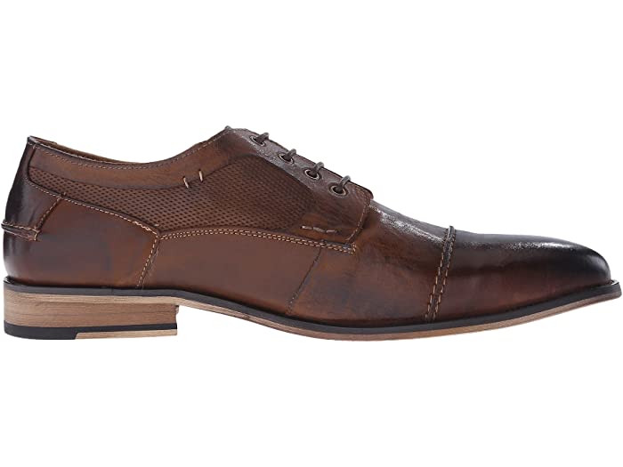 Steve Madden Jagwar dress shoes in brown leather with perforated accents, cap toe stitching, and stacked heel, side view.