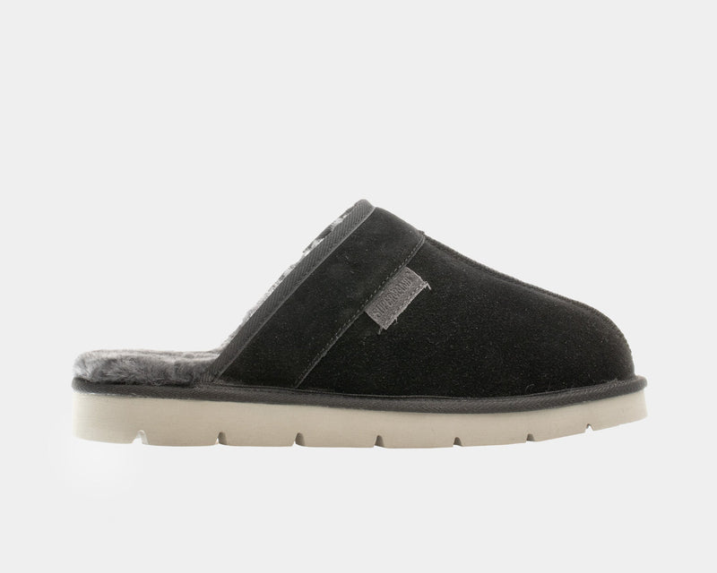 SuperLamb Khulan slippers in black suede with plush gray lining and beige treaded sole, side view.