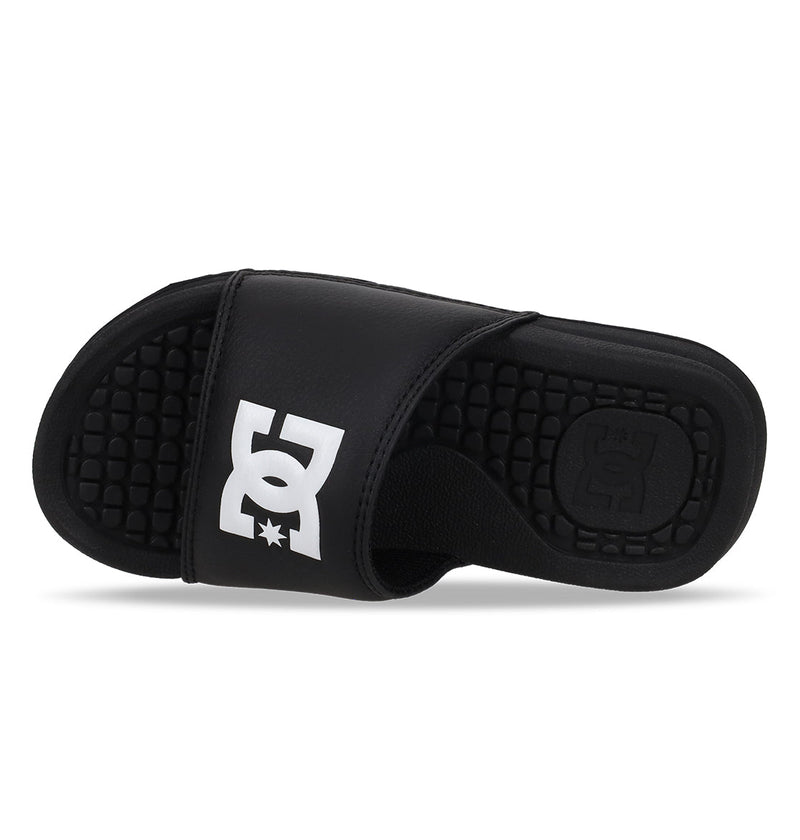 The Kids' Bolsa Slides by DC Shoes are black with a thick strap featuring a bold white logo and a textured footbed for comfort. Positioned on their side, these comfy sandals display both the top and inner sole.