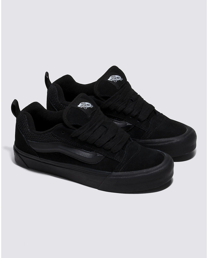 Vans Knu Skool Core sneakers in all-black with suede upper, padded tongue, and signature sidestripe, angled side view.