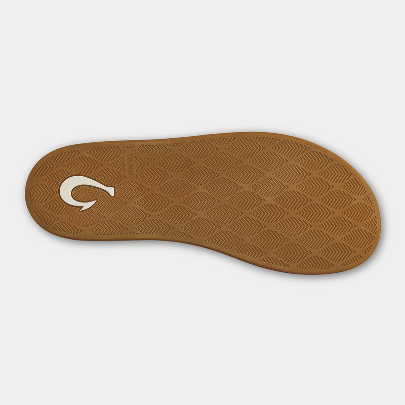 OluKai Ku'u sandal outsole in light brown with textured leaf pattern and branded logo detailing, sole/bottom view.