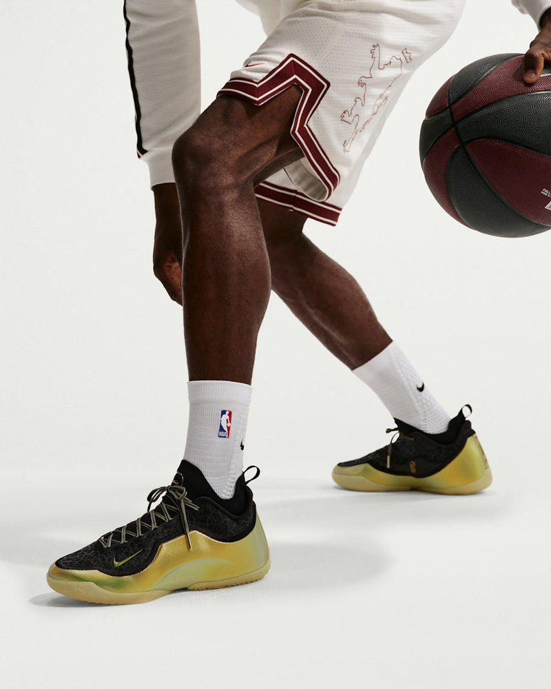 Nike LeBron XXIII Elite "Hurt Feelings" basketball shoes in black and metallic gold, low-top design with textured upper, worn by player in action.