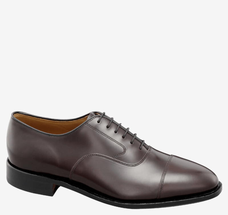 Johnston & Murphy Melton Cap Toe dress shoe in dark brown leather with a polished finish, cap toe detail, and lace-up closure, side view.