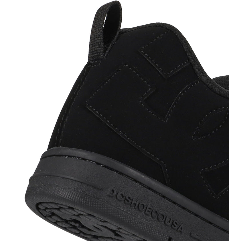 Close-up of a black sneaker with visible branding on a white background