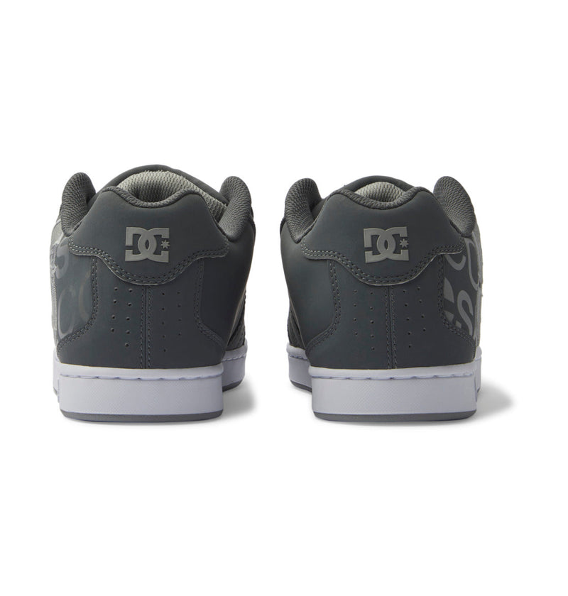 A pair of DC Shoes Men's Net Shoes in dark gray, shown from the back with the logo on the heel and white soles designed for all-day comfort.