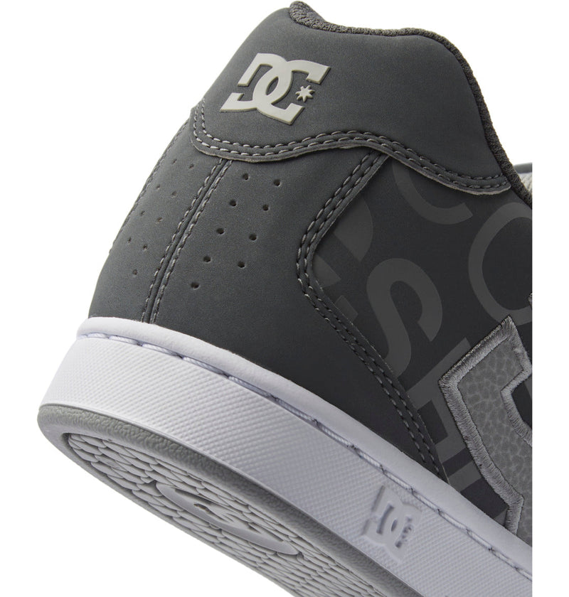 Close-up of the heel and side of the DC Shoes Men's Net Shoes in gray, featuring white branding, a white rubber sole, puffy design, visible stitching, and perforation for stylish looks and all-day comfort.