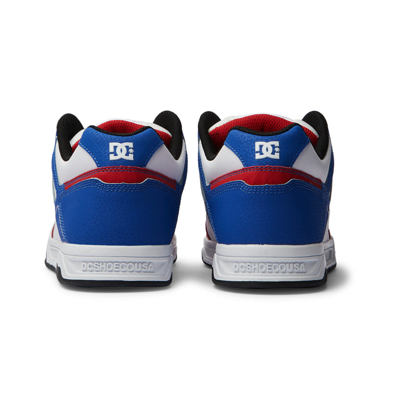 The Men's Stag Shoes by DC Shoes are seen from the back in blue, red, and white, with the DC logo on the heel, DCSHOECOUSA on white midsoles, an oversized puff, and a durable cupsole for comfort.
