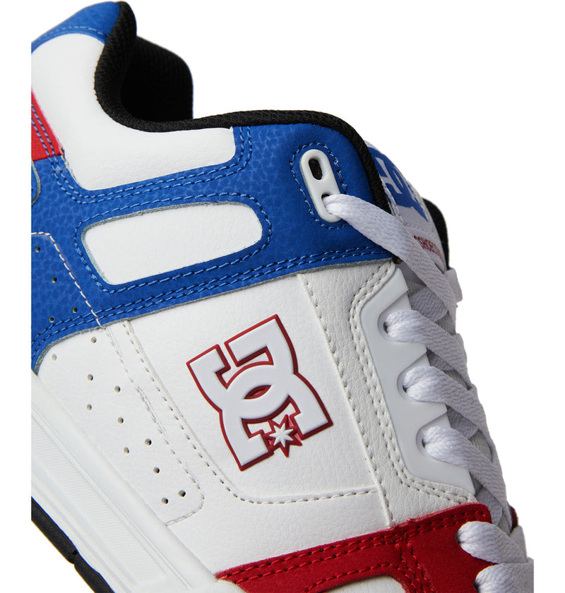 Close-up of DC Shoes Men's Stag shoe in white with blue and red accents, showcasing an oversized puff, durable cupsole, white laces, and the DC Shoes logo against a plain white background.