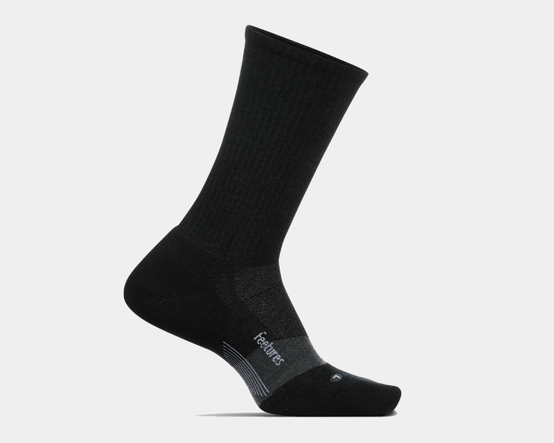 Feetures Merino 10 Max Cushion Crew socks in black featuring ribbed upper and reinforced cushioning, side view.