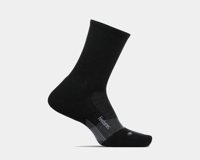 Feetures Merino 10 Ultra Light Cushion Mini Crew socks in black with targeted compression and seamless toe, side view.