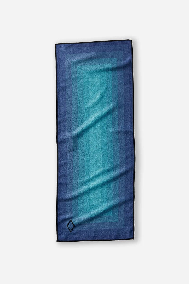Nomadix Mini Towel in shades of blue, featuring a geometric gradient design and black trim, flat, top view