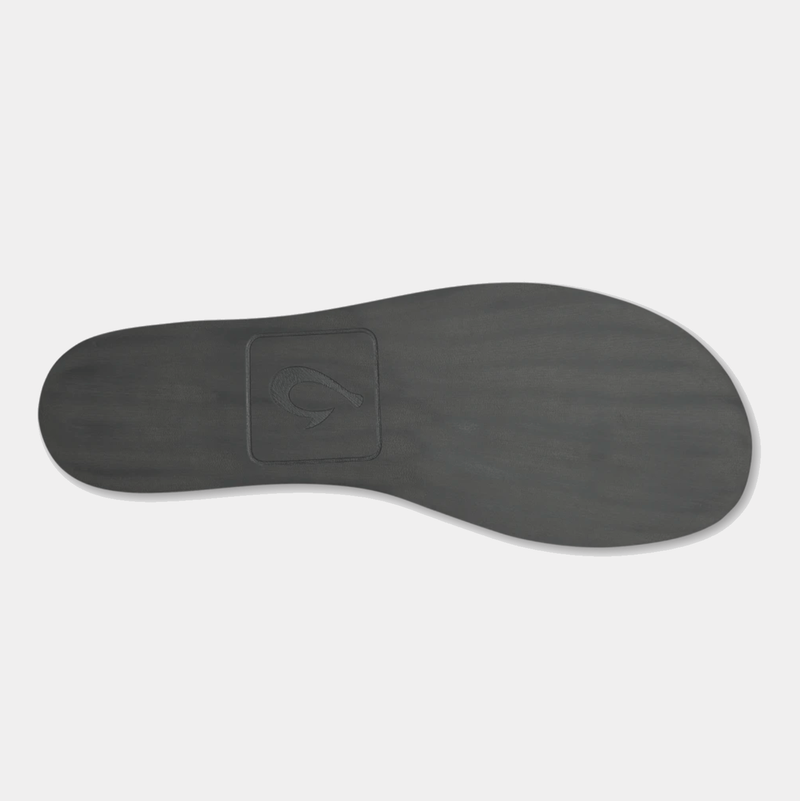 OluKai Moloa Hulu shoe outsole in dark gray rubber showing embossed logo design and smooth texture.