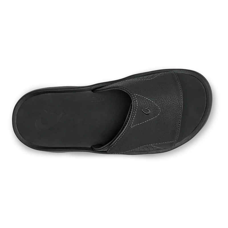 OluKai Nalu Slide sandals in black with textured leather upper and cushioned footbed, top view.