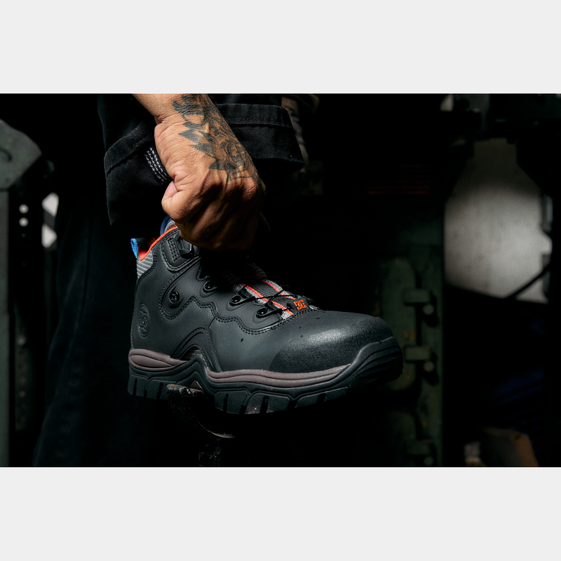 DC WorkCrew Navigator Work Hi Top Comp Toe work boots in black with a rugged leather upper, composite toe, and durable outsole, lifestyle context showing a worker.