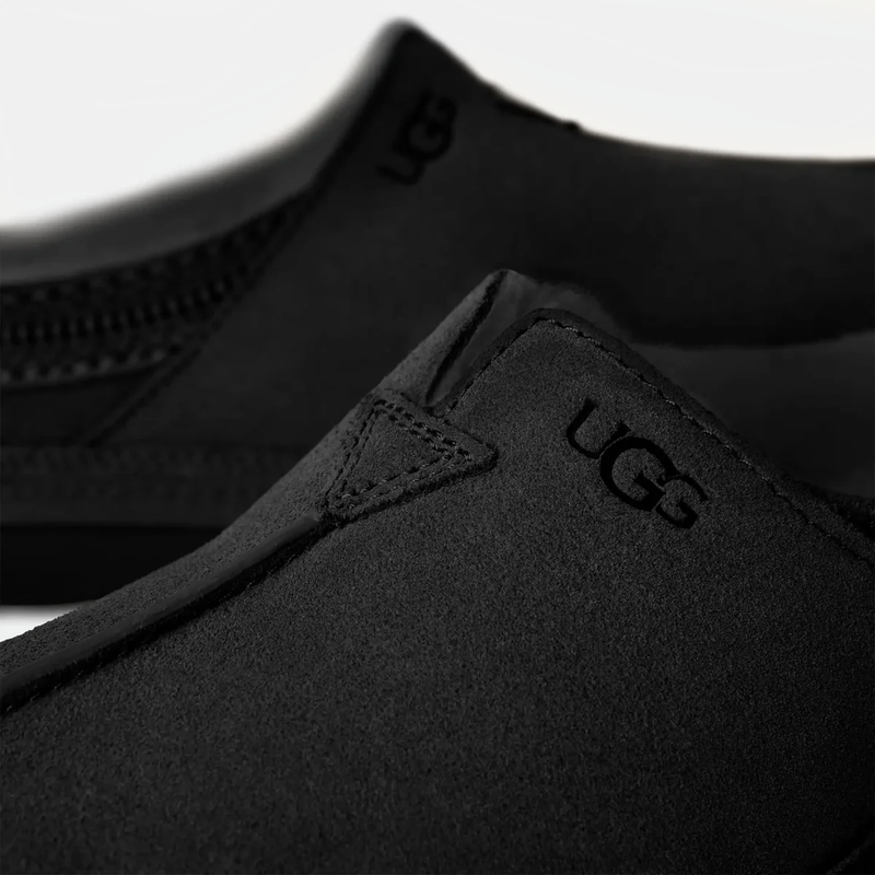 UGG Neuman shoes in black suede close-up showcasing stitching details and embossed brand logo.