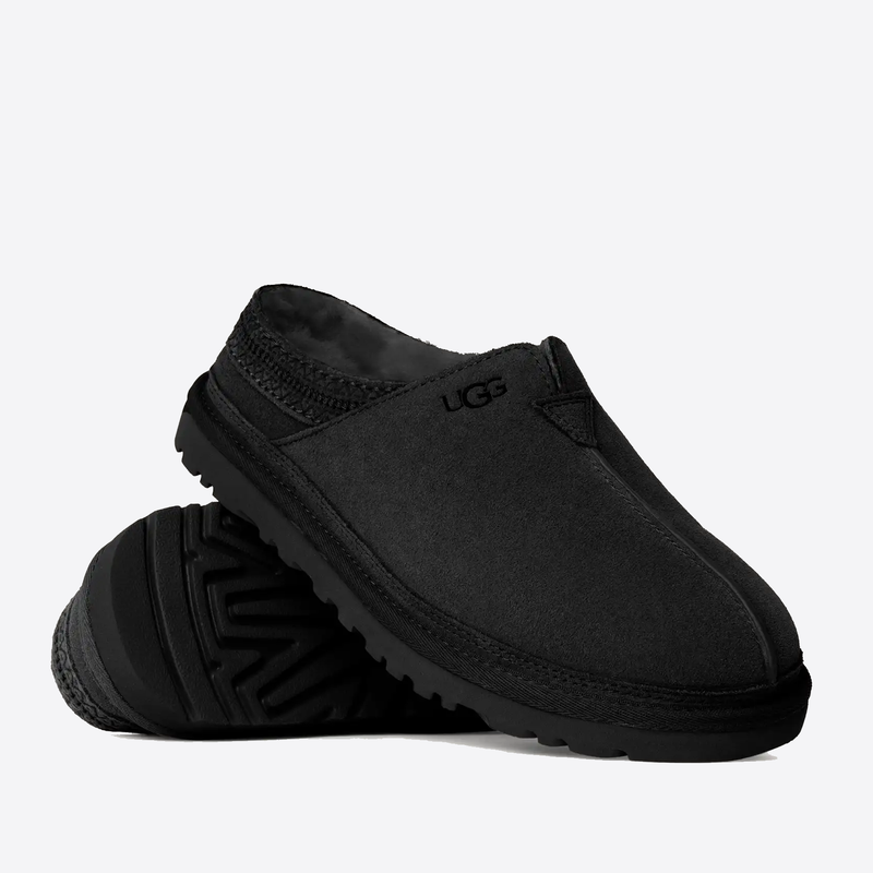 UGG Neuman slippers in black with suede upper, plush lining, and durable rubber outsole, angled side view.