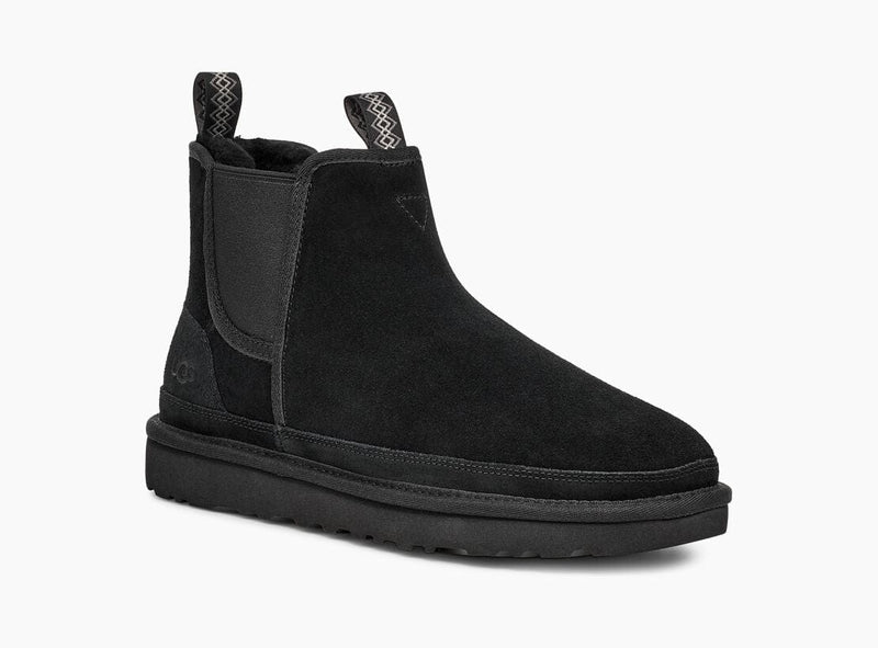UGG Neumel Chelsea boots in black suede with elastic side panels, rear pull tabs, and cushioned sole, angled side view.