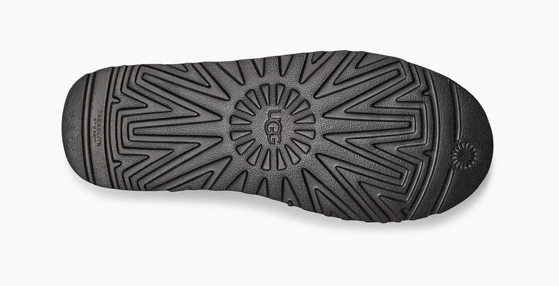 UGG Neumel Chelsea boot outsole in black, featuring embossed tread pattern with UGG branding, bottom view.