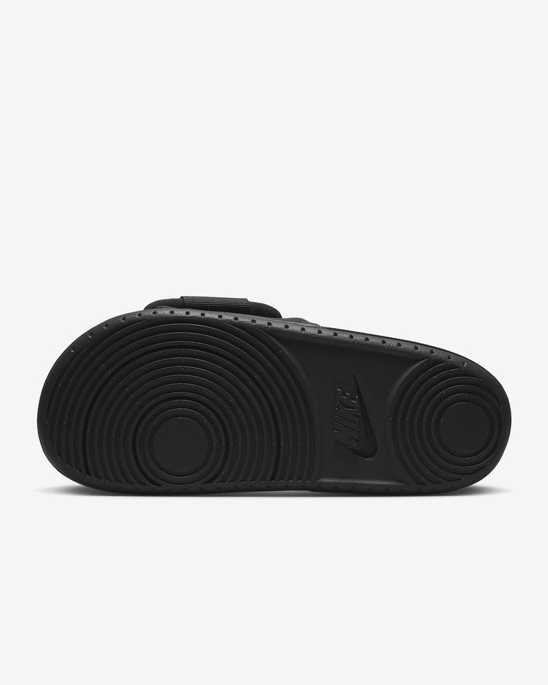 Nike Offcourt Adjustable Slide sandal outsole in black, featuring circular traction pattern and embossed Nike logo.