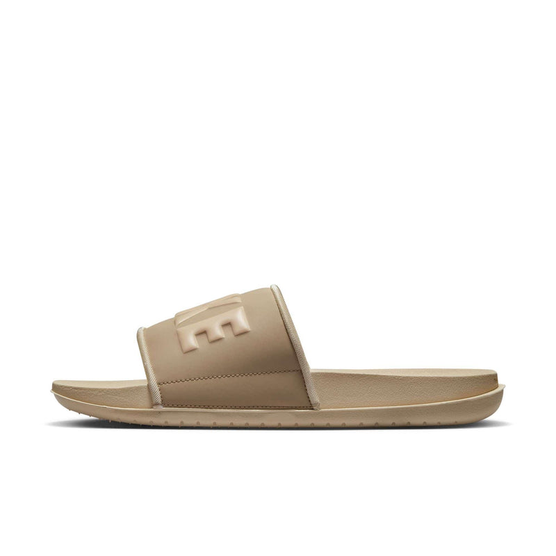 Nike Offcourt Slide sandals in beige with padded strap featuring embossed Nike logo, side view.