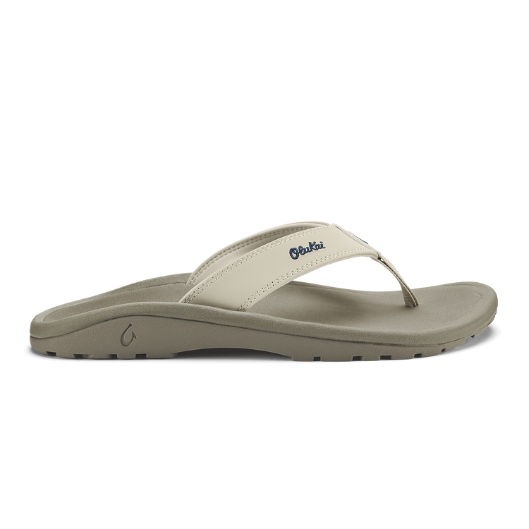 OluKai ‘Ohana sandals in beige with a textured footbed, durable strap, and grippy outsole, side profile view.