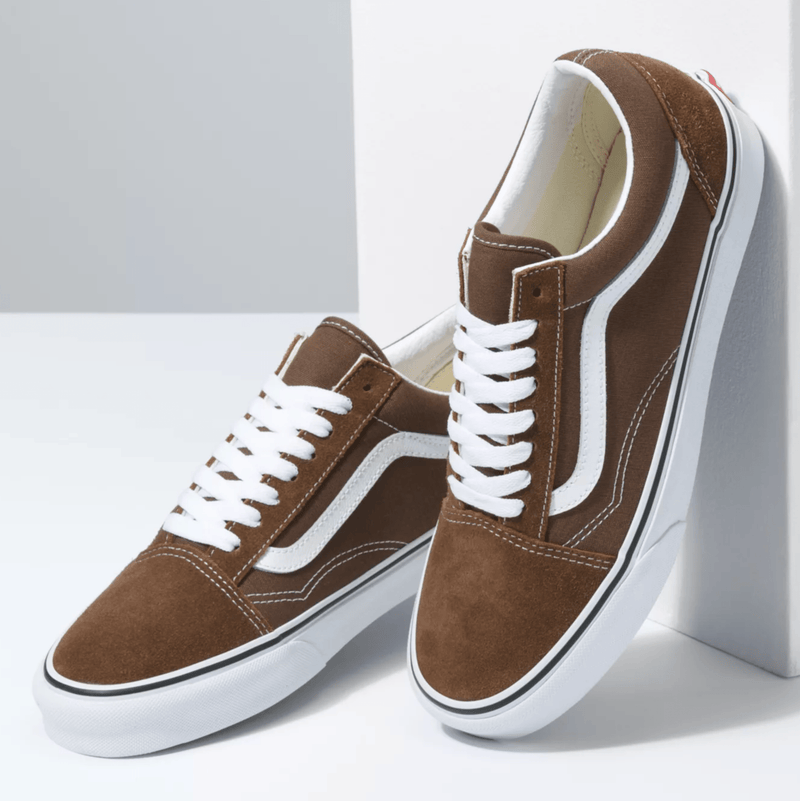 Vans Old Skool sneakers in brown suede with white side stripe, laces, and rubber outsole, front angle view.