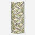 Nomadix Original Towel with tropical leaf pattern in green, beige, and yellow, lightweight microfiber material, front view.