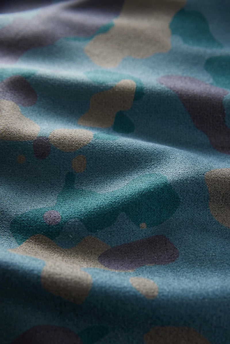 Nomadix Original Towel in blue with a multi-colored abstract pattern, close-up of textured fabric.