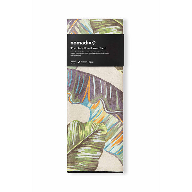 Nomadix Original Towel folded view featuring tropical leaf design in green, blue, orange, and purple with black packaging band detailing.