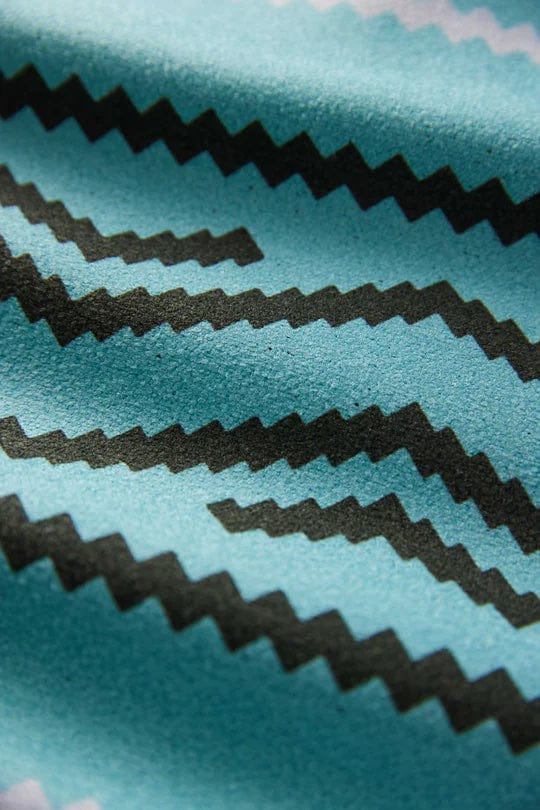 Nomadix Original Towel with teal background featuring black zigzag pattern, close-up view of fabric texture.