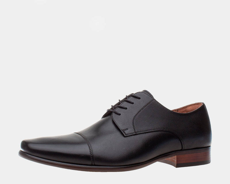 Florsheim Postino Cap Toe Oxford dress shoes in black leather with textured sides and brown wooden heel, side view.