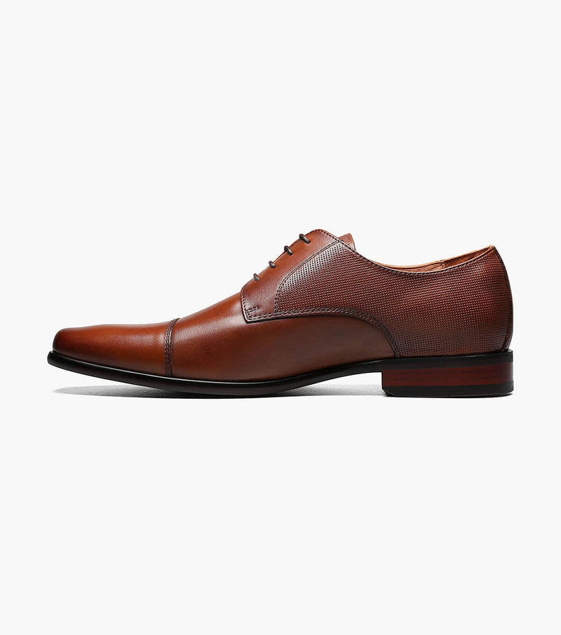Florsheim Postino Cap Toe Oxford dress shoes in rich brown leather with textured side panels and lace-up design, side view.