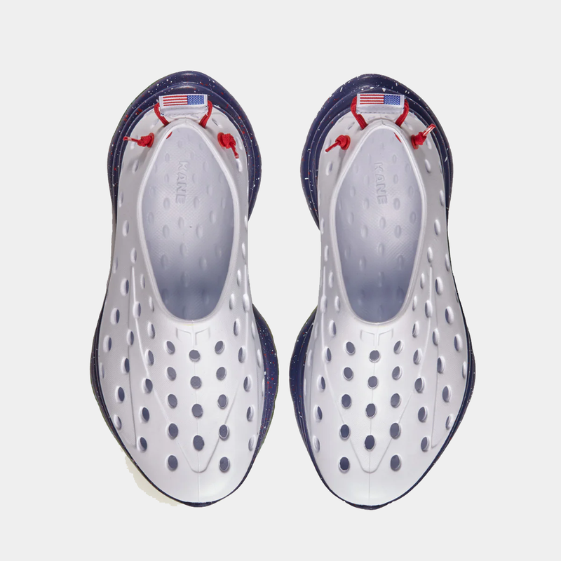 Kane Revive shoes in white with perforated design, red laces, and blue speckled soles, top view.
