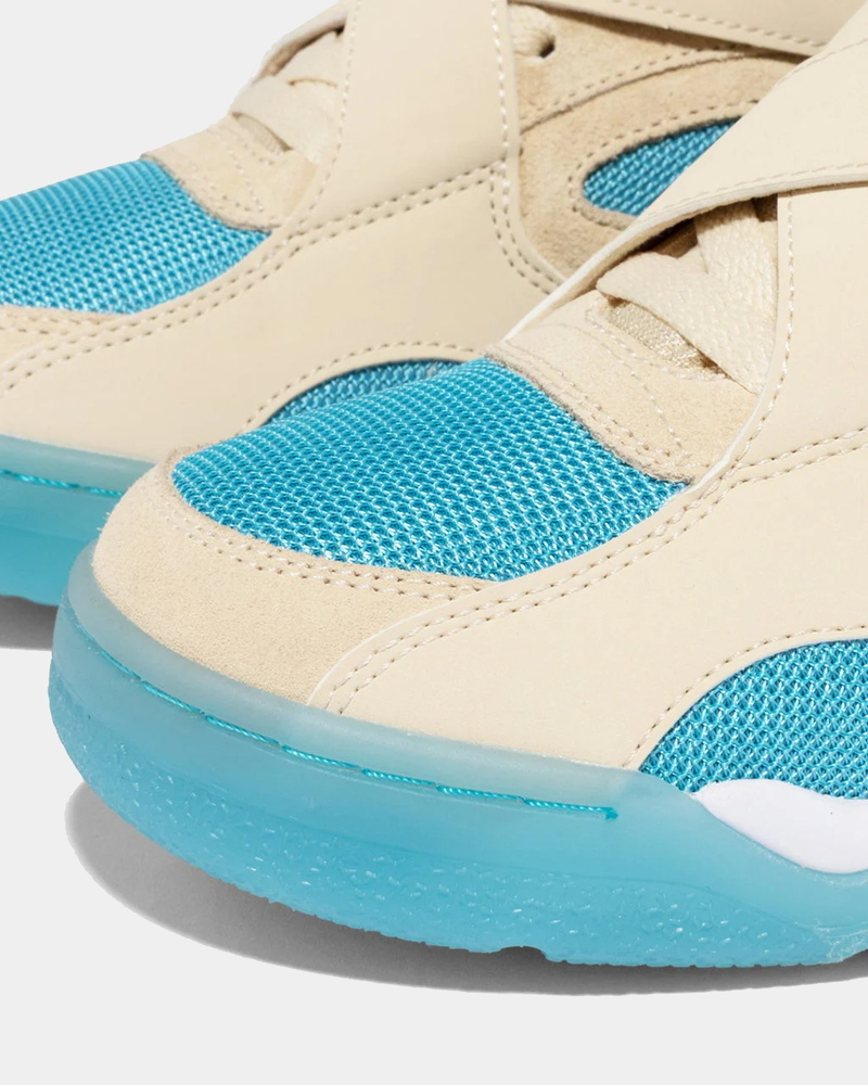Ewing Athletics ROGUE x ICE T sneakers, close-up showing beige suede overlays, bright blue mesh upper, and translucent blue sole.