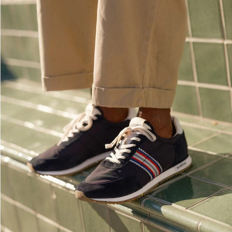 SeaVees Royal Runner sneakers in black with striped side design and white laces worn casually outdoors.