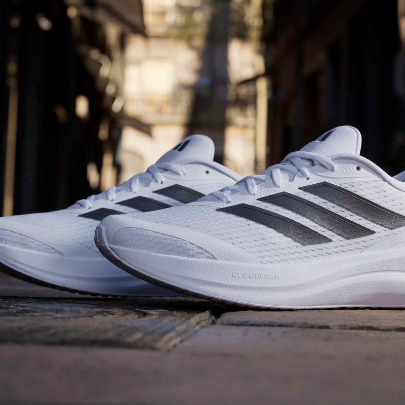 Adidas Runfalcon 6 running shoes in white with black stripes and Cloudfoam midsoles, side view.