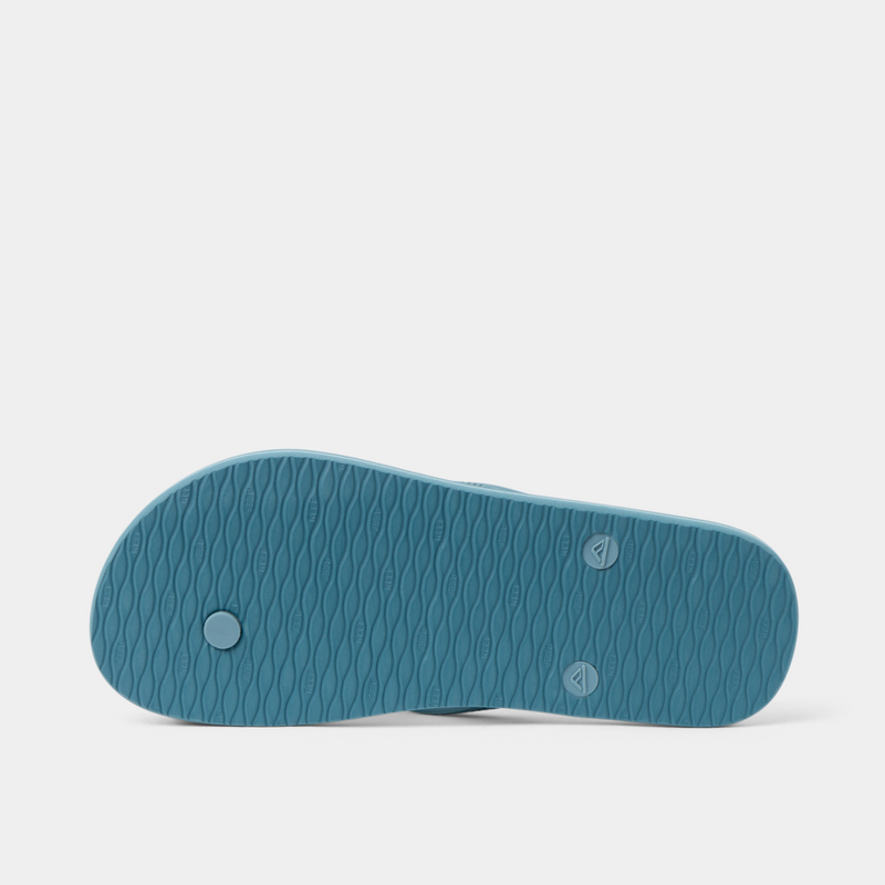 Reef Seaside Prints flip-flops blue sole with textured wave pattern, bottom view.
