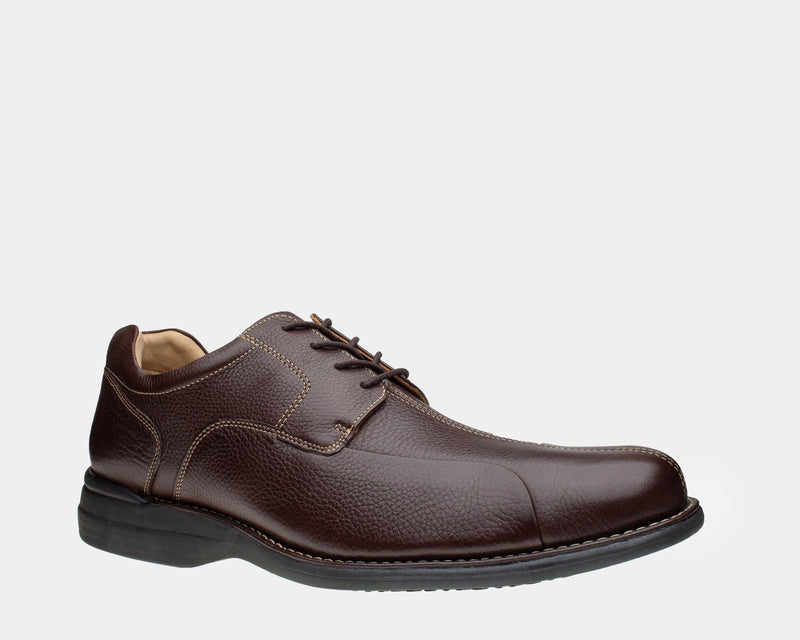 Johnston & Murphy Shuler Bicycle dress shoe in dark brown leather with textured finish, contrast stitching, and black outsole, side view.