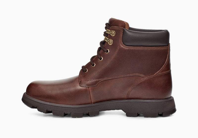 UGG Stenton boots in rich brown leather with padded collar, lace-up design, and rugged rubber outsole, side view.