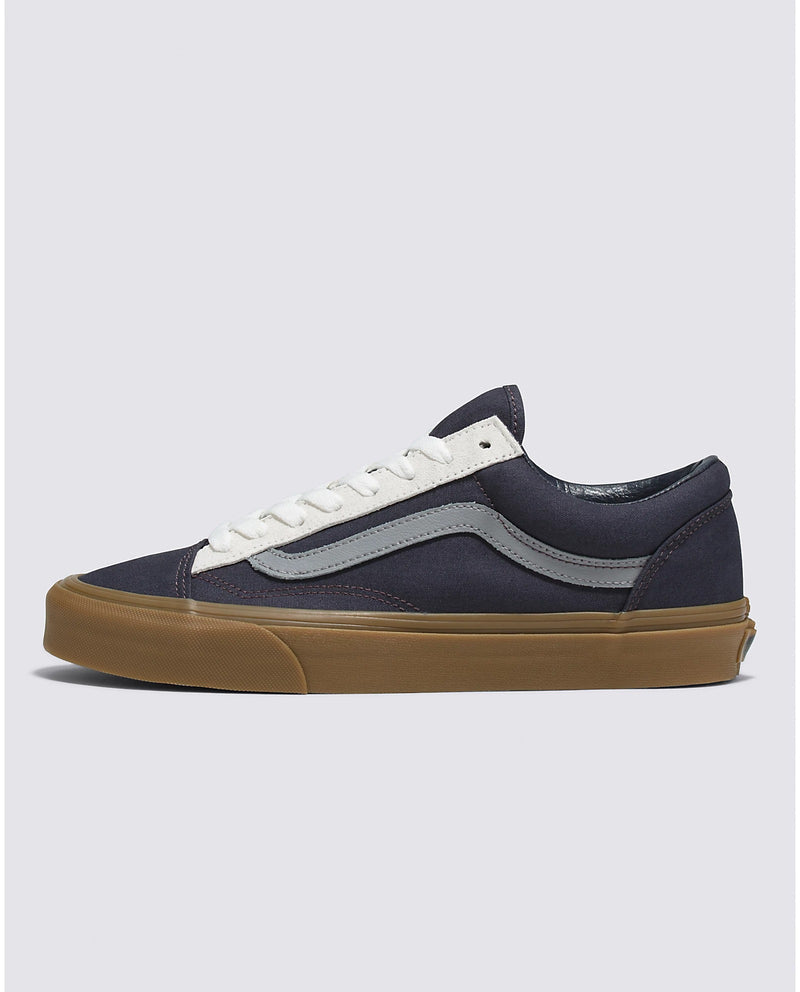 Vans Style 36 sneakers in navy blue with gray side stripe, white laces, and gum sole, side view.