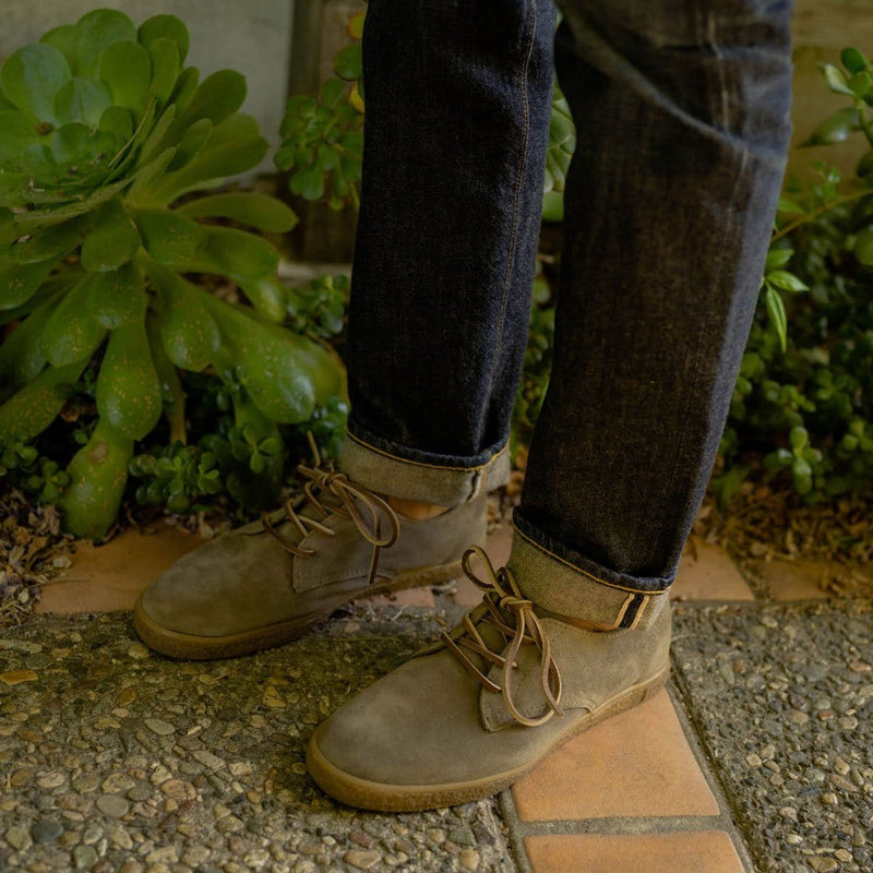 SeaVees Sun-Tans Buck casual shoes in taupe suede with lace closure and rubber sole, worn outdoors on stone path.